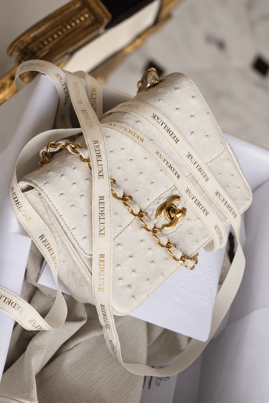 A woman seated with a pastel quilted Chanel mini bag