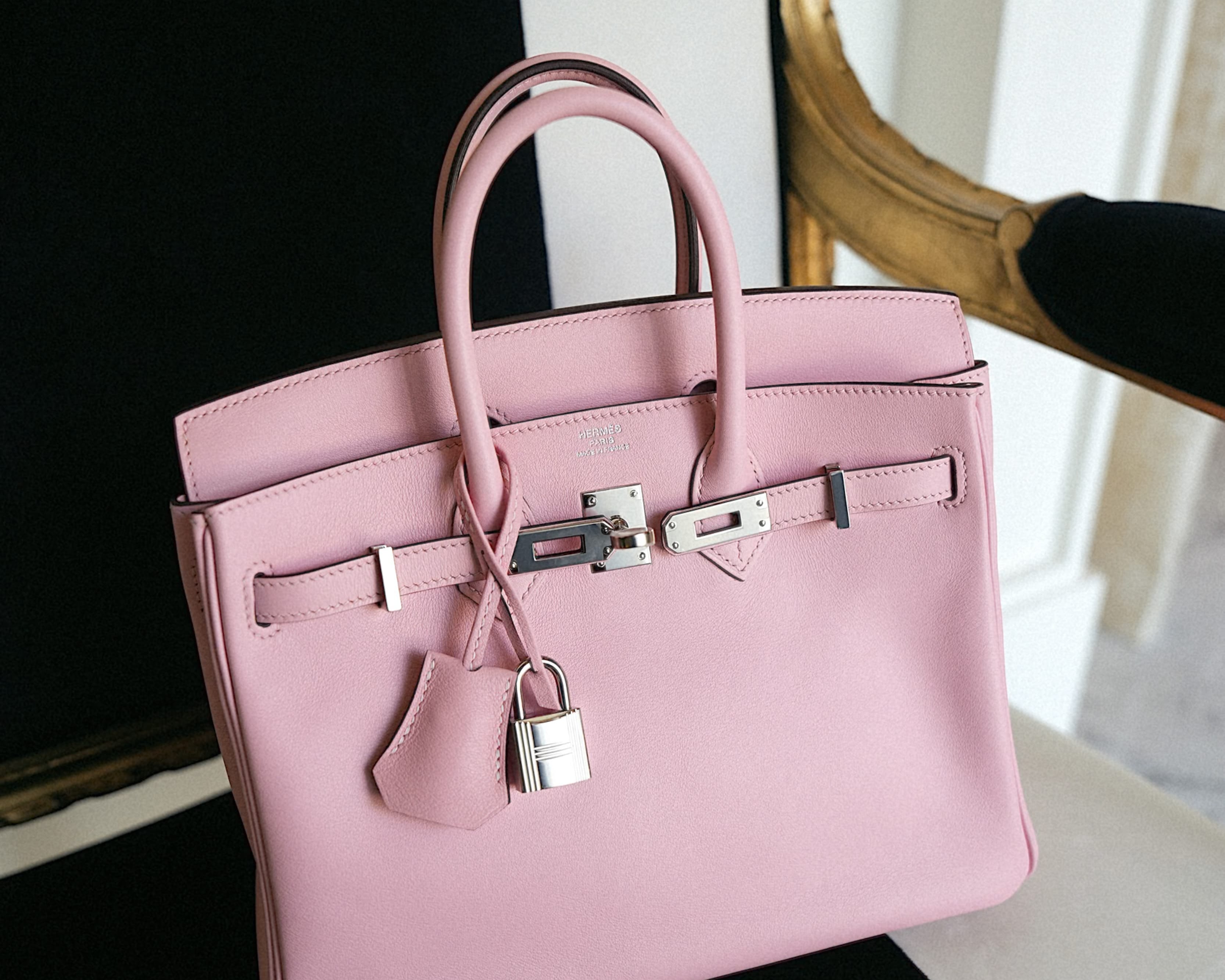 Hermès Kelly handbag, black leather, gold hardware, editorial photograph. Editorial imagery, availability varies.